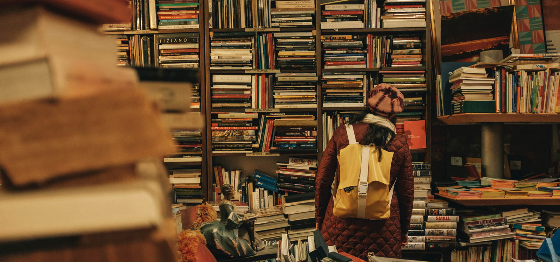 Frau steht vor einem chaotischen Bücherregal