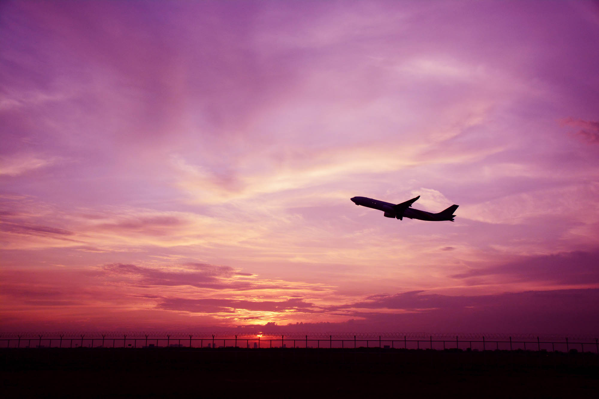 Silhouette eines Flugzeugs während eines Sonnenuntergangs